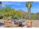 Inviting backyard seating area with a modern fire pit, set against a backdrop of desert landscaping and mountain views at 1702 E Staghorn Ln, Carefree, AZ 85377