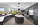 Modern kitchen with gray cabinets, large island, and a big window with a view of the desert landscape at 1702 E Staghorn Ln, Carefree, AZ 85377