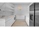 Well-lit laundry room with white cabinets, shelving, sink, and stainless steel refrigerator for efficient home chores at 1702 E Staghorn Ln, Carefree, AZ 85377