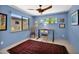 A bright office features blue walls, desert views, tile floors, a ceiling fan and natural light at 1702 E Staghorn Ln, Carefree, AZ 85377