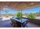 Covered outdoor dining space featuring a large glass-top table, offering a luxurious desert living experience at 1702 E Staghorn Ln, Carefree, AZ 85377