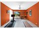 An orange workout room with bright light, tile floors, a treadmill, and backyard views at 1702 E Staghorn Ln, Carefree, AZ 85377