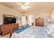 Comfortable bedroom featuring ensuite bathroom, dresser with mirror, and ceiling fan at 17651 N Coconino Dr, Surprise, AZ 85374