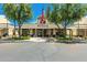 Attractive community clubhouse with an American flag, mature shade trees, and manicured landscaping at 17651 N Coconino Dr, Surprise, AZ 85374