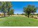 Beautiful golf course with a vibrant green fairway, framed by mature trees and clear blue skies, inviting a game of golf at 17651 N Coconino Dr, Surprise, AZ 85374