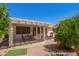 Lovely covered patio with dining table, small seating area, and a well manicured yard at 17651 N Coconino Dr, Surprise, AZ 85374