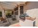 Covered outdoor patio featuring comfortable seating, a dining area, and a built-in grill at 17651 N Coconino Dr, Surprise, AZ 85374