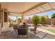 Inviting covered patio area featuring a dining set and a well-maintained backyard landscape at 17651 N Coconino Dr, Surprise, AZ 85374