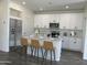 Modern kitchen with white cabinets, a spacious island with seating, and stainless steel appliances at 17961 W Sand Hills Rd, Surprise, AZ 85387