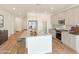 A sunlit kitchen boasts stainless steel appliances, a granite island with barstool seating, and wood-look flooring at 17969 W Sand Hills Rd, Surprise, AZ 85387