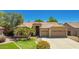 Charming single-story home with a three-car garage, lush green lawn, and desert landscaping at 1811 S Brentwood Pl, Chandler, AZ 85286