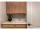 Well-lit laundry room showcasing a sink with storage cabinets and a neutral-colored countertop at 1811 S Brentwood Pl, Chandler, AZ 85286