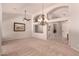Spacious living room with high ceilings, elegant chandelier, and neutral carpet at 1811 S Brentwood Pl, Chandler, AZ 85286