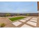 Backyard featuring artificial grass, stone pavers, desert landscaping, and privacy fence at 18244 W Soft Wind Dr, Surprise, AZ 85387