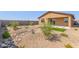 Low-maintenance backyard with desert landscaping, small trees, and a small green lawn area at 18244 W Soft Wind Dr, Surprise, AZ 85387