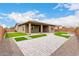 Backyard with artificial turf, desert landscaping, and covered patio at 18453 W Elwood St, Goodyear, AZ 85338