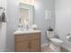 Stylish powder bathroom with vanity, toilet, mirror and neutral tones at 18453 W Elwood St, Goodyear, AZ 85338