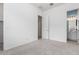 A carpeted bedroom with neutral walls, featuring a view into the bathroom at 18453 W Elwood St, Goodyear, AZ 85338