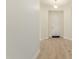 Bright hallway with light wood floors, neutral paint, and a view of the home's entry door at 18453 W Elwood St, Goodyear, AZ 85338
