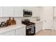 Close-up of modern kitchen with stainless steel oven, cooktop, microwave and white cabinets at 18453 W Elwood St, Goodyear, AZ 85338