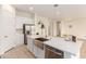 Kitchen island with stainless steel sink and faucet, white cabinets, and stainless steel refrigerator at 18453 W Elwood St, Goodyear, AZ 85338
