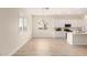 Open concept floorplan with a view of the modern kitchen with white cabinetry and light wood floors at 18453 W Elwood St, Goodyear, AZ 85338