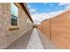 Paver walkway between home and block fence with neutral rock ground cover, leading to gate at 18453 W Elwood St, Goodyear, AZ 85338