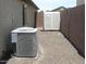 Side yard with AC unit, white storage shed, and desert landscaping next to block fence at 18599 W Illini St, Goodyear, AZ 85338