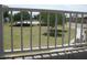 Community view of the park area through a white iron fence, with shade trees and sidewalk at 18599 W Illini St, Goodyear, AZ 85338