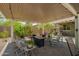 Relaxing backyard patio with mature trees, and comfortable rocking chair seating at 18653 W Mescal St, Surprise, AZ 85388