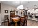 Formal dining area open to kitchen with modern light fixture and wooden table at 18653 W Mescal St, Surprise, AZ 85388