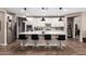 Modern kitchen with large island, pendant lighting, stainless steel appliances, and wood-look tile floors at 18653 W Mescal St, Surprise, AZ 85388