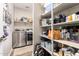 Walk-in pantry with well-organized shelves and adjacent laundry area, designed for convenient storage and chores at 18653 W Mescal St, Surprise, AZ 85388