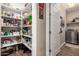 Walk-in pantry with white shelving and tile flooring conveniently located near the laundry area at 18653 W Mescal St, Surprise, AZ 85388
