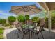Backyard patio featuring an outdoor dining table and chairs under a large shade umbrella at 18653 W Mescal St, Surprise, AZ 85388