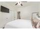 Cozy bedroom featuring a ceiling fan, TV, closet and comfortable bed with white comforter and door to the rest of the house at 19606 N 23Rd Way, Phoenix, AZ 85024