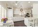 All-white kitchen featuring a ceiling fan and breakfast bar at 19606 N 23Rd Way, Phoenix, AZ 85024