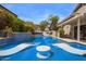 Resort style pool with a waterfall feature and submerged loungers with blue tile, patio table and hot tub at 19606 N 23Rd Way, Phoenix, AZ 85024