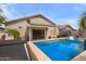 Backyard pool with hot tub, submerged loungers, sliding door and patio with table and umbrella at 19606 N 23Rd Way, Phoenix, AZ 85024