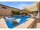 Resort style pool with a waterfall feature and submerged loungers with blue tile and patio and awning at 19606 N 23Rd Way, Phoenix, AZ 85024