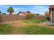 Spacious backyard featuring a partial patio, block fence, and mature landscaping at 2027 S Rowen St, Mesa, AZ 85209