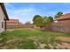 Spacious backyard featuring green grass, mature tree and block wall fence at 2027 S Rowen St, Mesa, AZ 85209