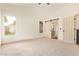 Primary bedroom with natural light, barn door to the primary bath, and neutral carpeting at 2027 S Rowen St, Mesa, AZ 85209
