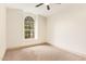 Bright bedroom featuring neutral walls, carpet, modern ceiling fan, and window with arched top at 2027 S Rowen St, Mesa, AZ 85209