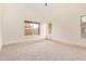 Spacious bedroom featuring neutral carpet, light walls, and plentiful natural light from various windows at 2027 S Rowen St, Mesa, AZ 85209