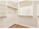 Bright, walk-in closet with wood floor and white shelving and cabinets at 2027 S Rowen St, Mesa, AZ 85209