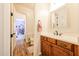 Bathroom with wood floors, stained cabinets, white counters, and an ornate mirror at 20421 W Legend Trl, Buckeye, AZ 85396