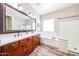 Bright bathroom with double sink vanity, soaking tub, and glass-enclosed shower at 20421 W Legend Trl, Buckeye, AZ 85396