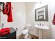 Powder room featuring a pedestal sink, toilet and dark wood-style flooring at 20421 W Legend Trl, Buckeye, AZ 85396