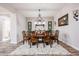 Dining room with a wood table, seating for six, chandelier lighting, and a neutral wall color at 20421 W Legend Trl, Buckeye, AZ 85396